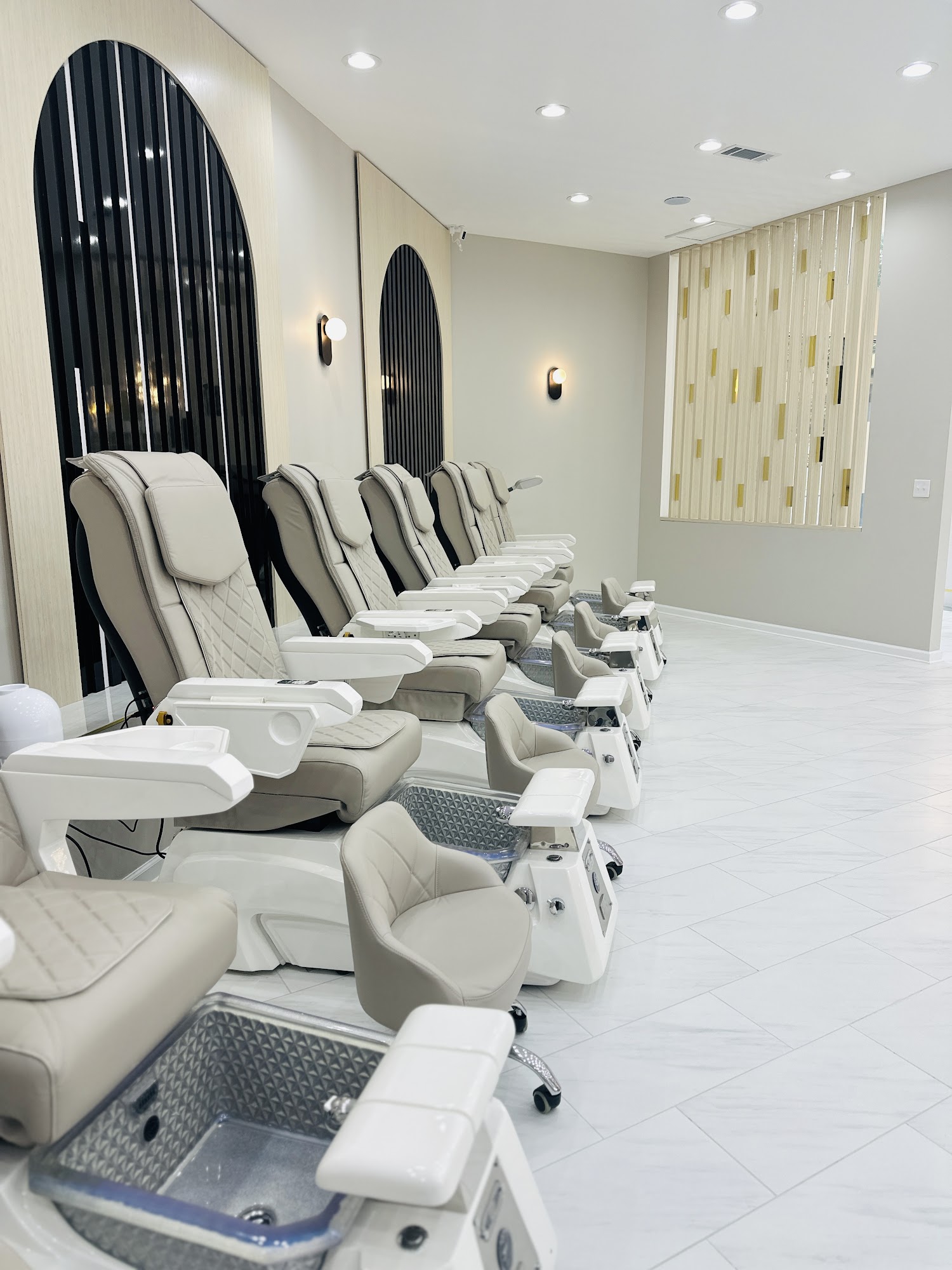 Pedicure row with arched black mirrors and gold wall details